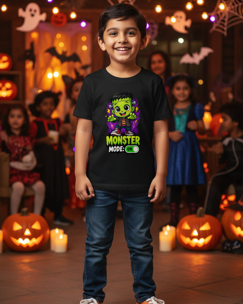 A black short-sleeve kids' t-shirt featuring a cartoon graphic of Frankenstein's monster with green skin, purple lightning effects, and the text 'MONSTER MODE: ON' printed on the front.